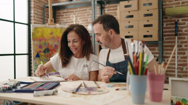 Man and woman couple drawing on notebook at art studio