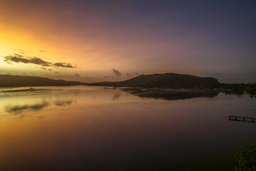 Fototapeta na wymiar Hazy Sunrise Waterscape with Reflections