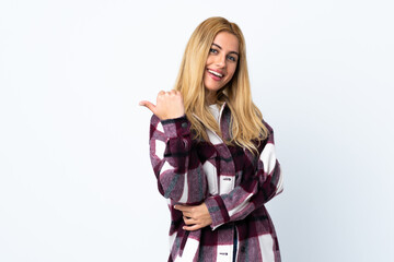 Young Uruguayan blonde woman over isolated white background pointing to the side to present a product