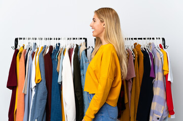 Young Uruguayan blonde woman in a clothing store laughing in lateral position