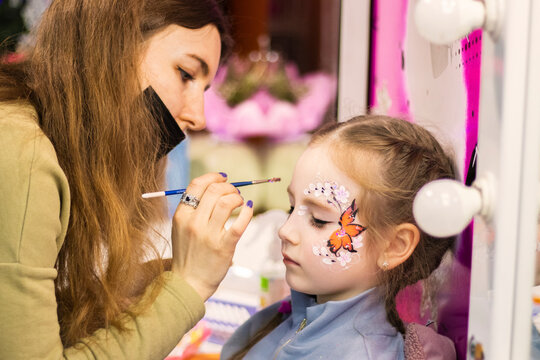 selective focus. A makeup artist works. childrens makeup face paint drawings Girls face painting. Little girl having face painted on birthday party. closed eyes. High quality photo