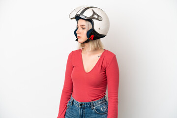 Young caucasian woman with a motorcycle helmet isolated on white background looking to the side