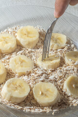 Fototapeta na wymiar flaked oats and sliced banana, on a plate that is on a table with natural light,copy space in several parts