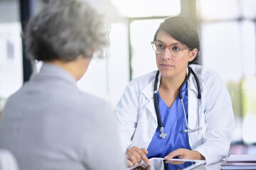 Im afraid things arent looking too well.... Cropped shot of a doctor showing a patient something on a digital tablet.