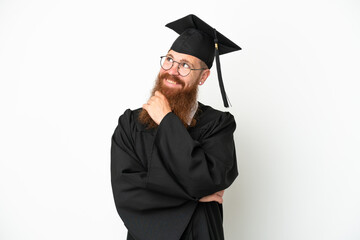 Young university graduate reddish man isolated on white background looking up while smiling