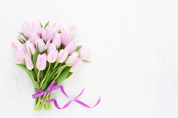 Pink tulips bouquet with pink ribbon on white background. Mothers Day, Valentines Day, birthday concept