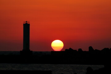 だるま夕日と灯台　（高知県　室戸市　室戸岬漁港）