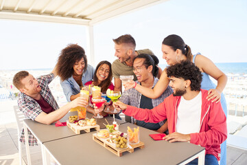 Multiracial Young people Friends having fun together toasting cocktails at rooftop. Social community life style concept