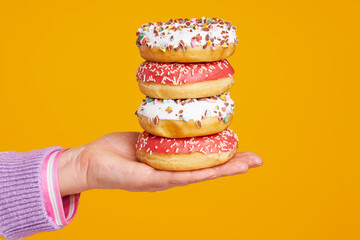 Young beautiful woman over yellow background with donuts