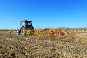Farmers use a disc rake to collect straw in the field, North China