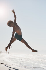 Obraz premium My heart is so happy when I dance. Full length shot of a handsome young man mid air while dancing on the beach during the day.