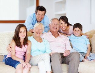 Fototapeta premium Going through life together - Family Support. Three generations of family sitting together affectionately on the lounge couch.
