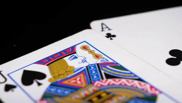 Camera pans across a pair of cards arranged as a hand of perfect blackjack, cards games concept