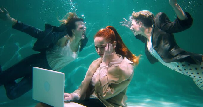 HEADACHE AND MIGRAINE Young stressed business woman using laptop touching head underwater, partners shouting slow motion