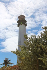Fototapeta na wymiar Wide shot of a white lighthouse on a nice day with a blue sky background 