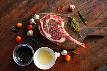 Sliced grilled thai steak served on white plate with grilled sliced lemon, tomatoes, garlic