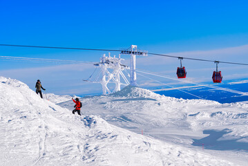 Fototapeta na wymiar Red cable car in a ski resort in the Alps. Red gondola funicular in a ski resort, sweden, frosty sunny day
