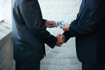 Nice doing business with you. Two corporate businessmen shaking hands and making a financial deal. - obrazy, fototapety, plakaty