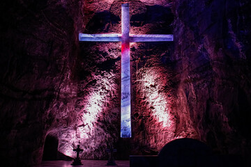 Illuminated cross in famous underground Salt cathedral of Zipaquira in violet light, Colombia