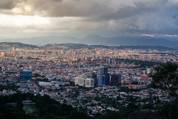 Panoramic view over the high plateau with the Colombian capital Bogota with dramatic cloudy sky and sunlight
