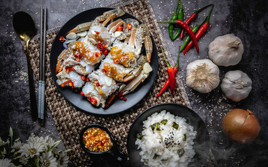 Pickled Crab put on a black plate on a black background.