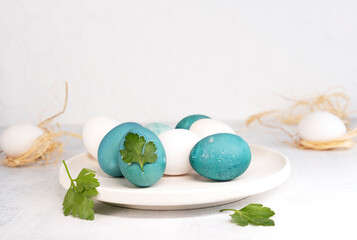 Painting Easter eggs. Natural coloring Easter eggs in blue color. Parsley leaf design.