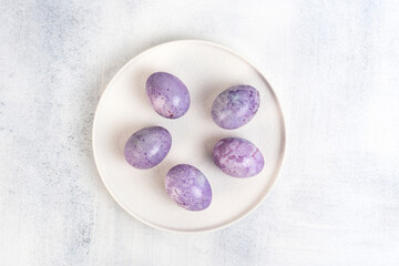 Coloring Easter eggs with natural dye carcade tea from hibiscus flowers. Trendy very peri colour with marble effect. Close-up.