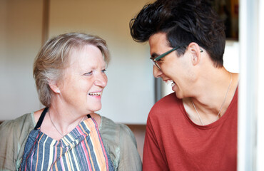 Theyve got a similar sense of humor - Mother and son. Young guy sharing a joke with his mom at home.