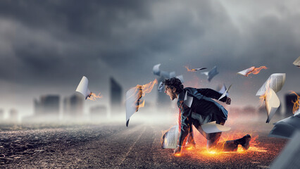 Determined businessman leaving fire trails on asphalt