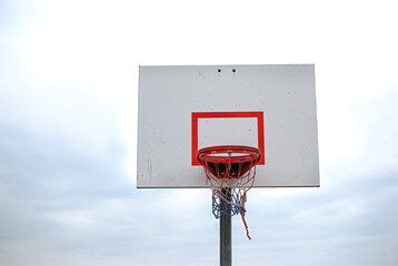 Low angle of basketball hoop with red white blue net - obrazy, fototapety, plakaty