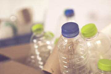 Close up waste which able recycle , plastic bottle and paper cardboard in separated in box waiting to recycling process , selective focus