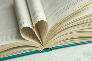 an open book with folded pages in the shape of a heart 