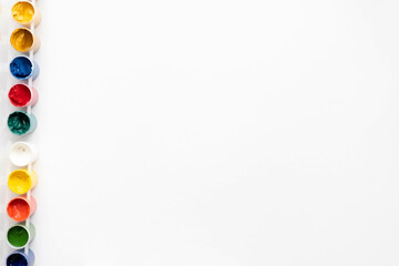 Flat composition a set of multi-colored paints in jars. Space for the text.