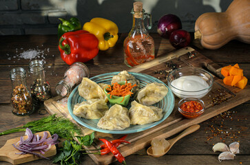 manti with meat and vegetables on a wooden table