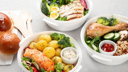 Healthy meal prep in lunch boxes on light background.