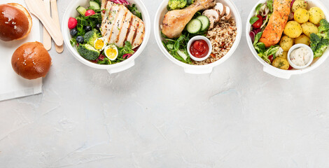 Healthy meal prep in lunch boxes on light background.