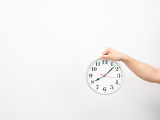 Hand holding analog clock copy space white background