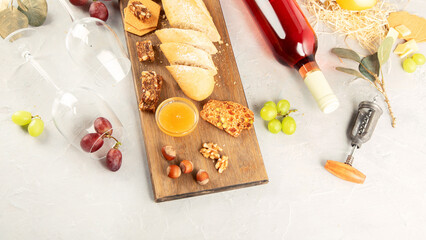 Bottle of rose wine with snacks on gray background.