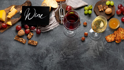 Red wine with appetizers on gray background.