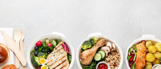 Healthy meal prep in lunch boxes on light background.