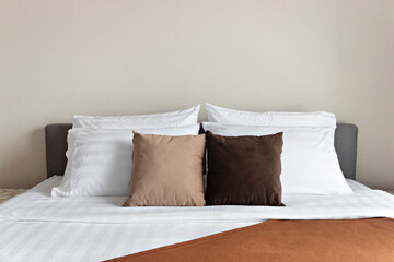 Many soft pillows on comfortable bed indoors