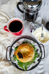 Home Baked Jewish pastry. Bagel Sandwich with Black Caviar, Sesame, Poppy Seeds Toppings and Mashed Avocado Fried Egg and Rocket Herbs Fillings. Luxurious meal with pinch of saltiness