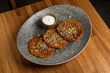 Vegetable pancakes with sour cream and garnished with seeds