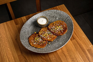 Vegetable pancakes with sour cream and garnished with seeds