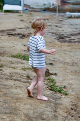 A little boy runs along the sandy beach along the seashore - 490998039