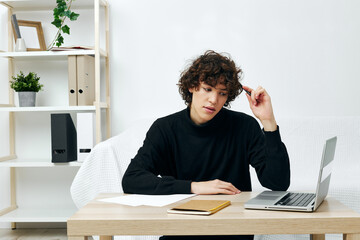 guy sitting on the couch at the table in front of a laptop communication