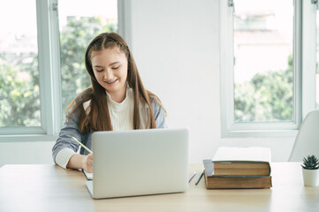 Happy girl student online learning class with laptop computer at home