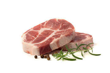 A piece of marbled raw pork or beef steak with a sprig of rosemary and peppercorns on a white background.