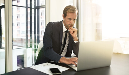 Fototapeta premium Focused on the task at hand. Shot of a businessman using his laptop.