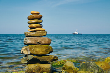 Stone pyramid on a pebble beach. Symbolizes stability and harmony